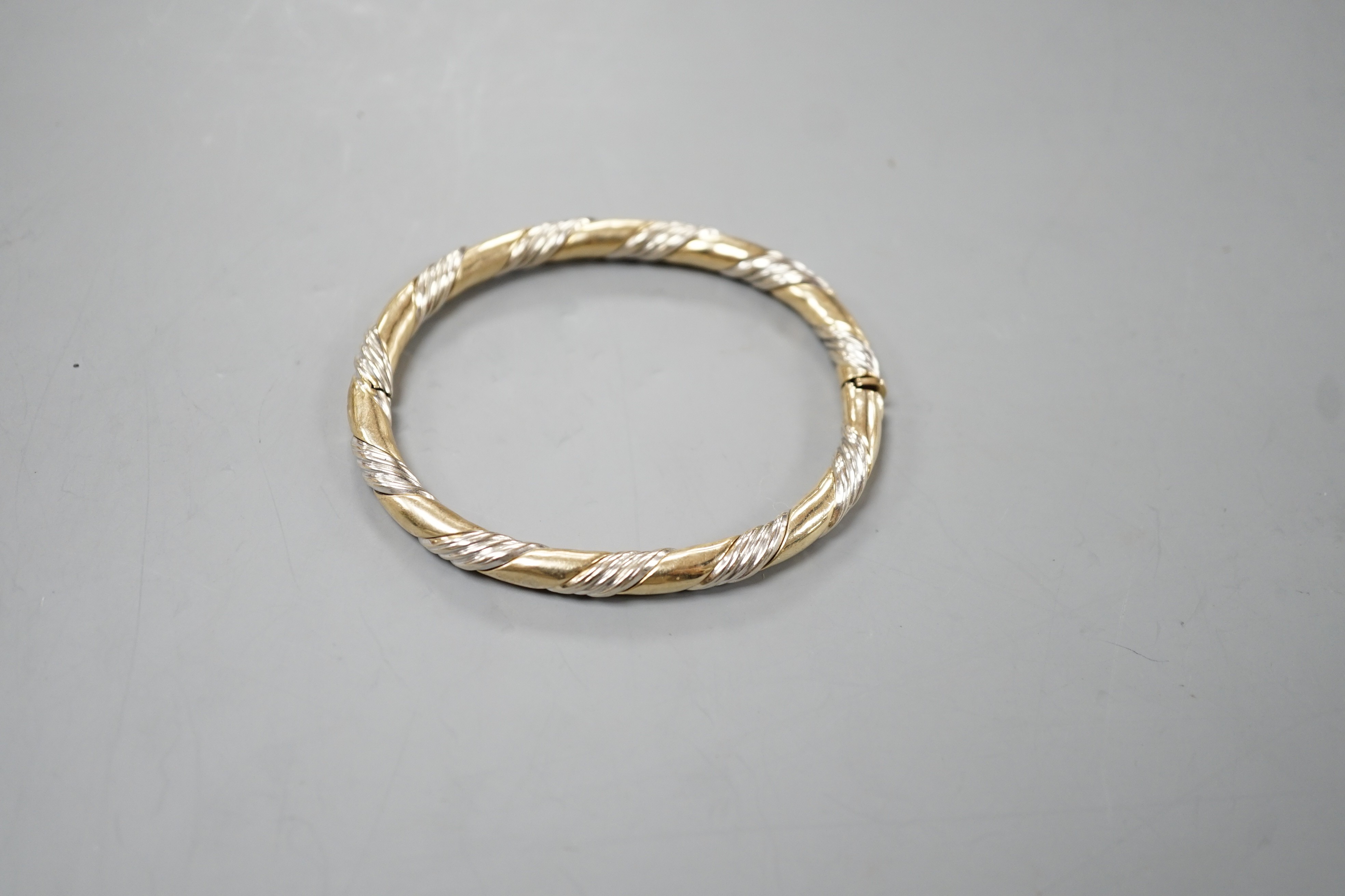 A modern two colour 9ct gold hinged bangle, interior diameter 58mm, 18.7 grams.